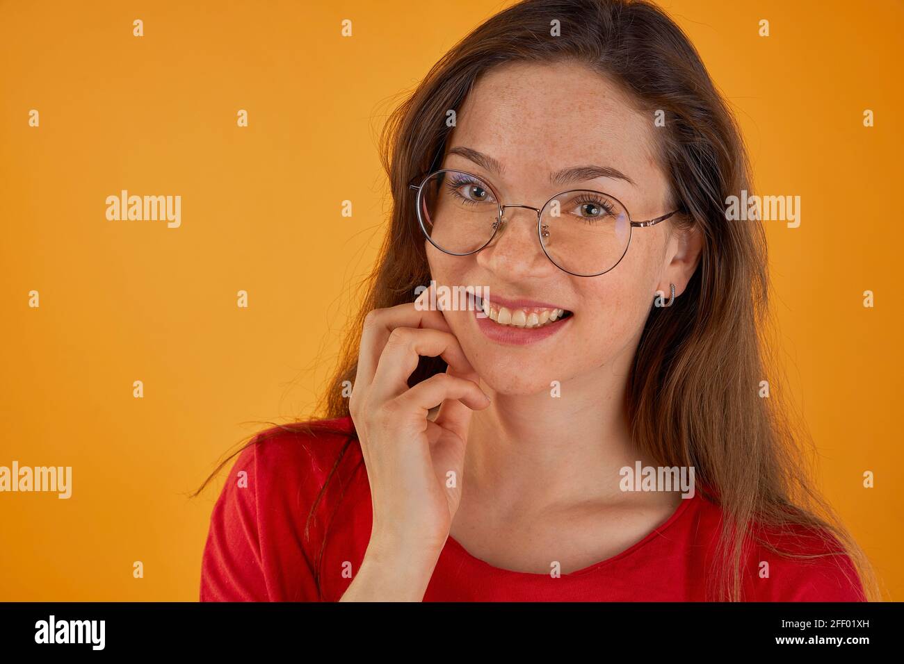 Foto-Porträt von lächelnden fröhlichen Arbeiterinnen tragen Brille isoliert Auf hellorangefarbenem Hintergrund Stockfoto