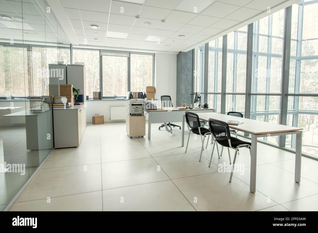 Moderner Büroraum mit Panoramafenster, ausgestattet mit Tischen und Stühlen, leeres Büro Stockfoto