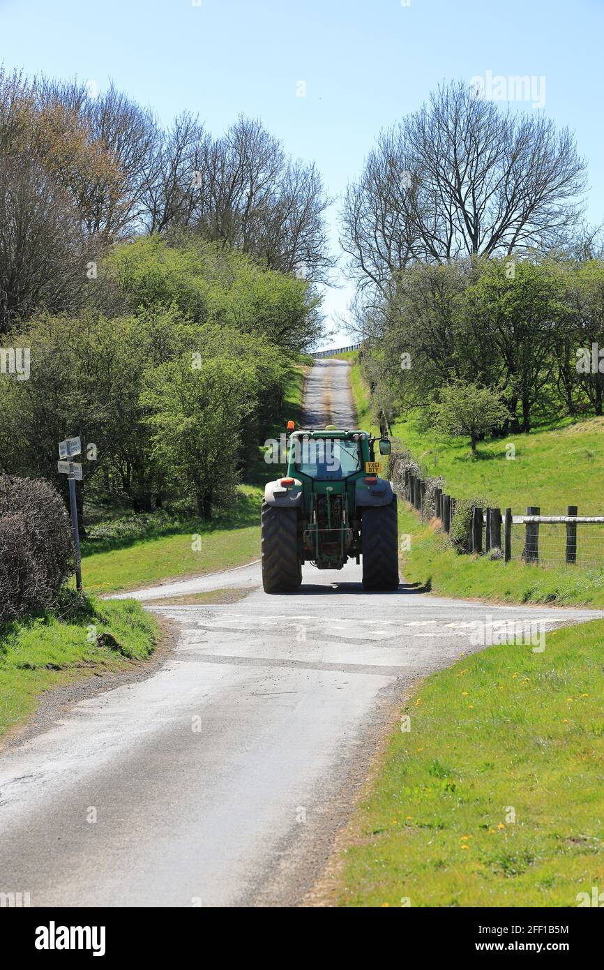 Landwirt, der seinen Traktor auf den Landstraßen in den Cotswolds fährt Stockfoto