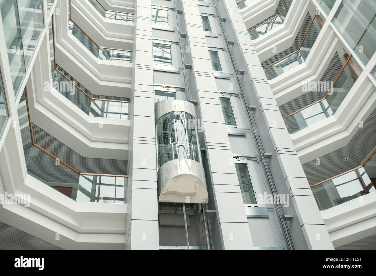 Gläserne Aufzüge in der runden Bürolobby mit modernem, minimalistischem Design Stockfoto