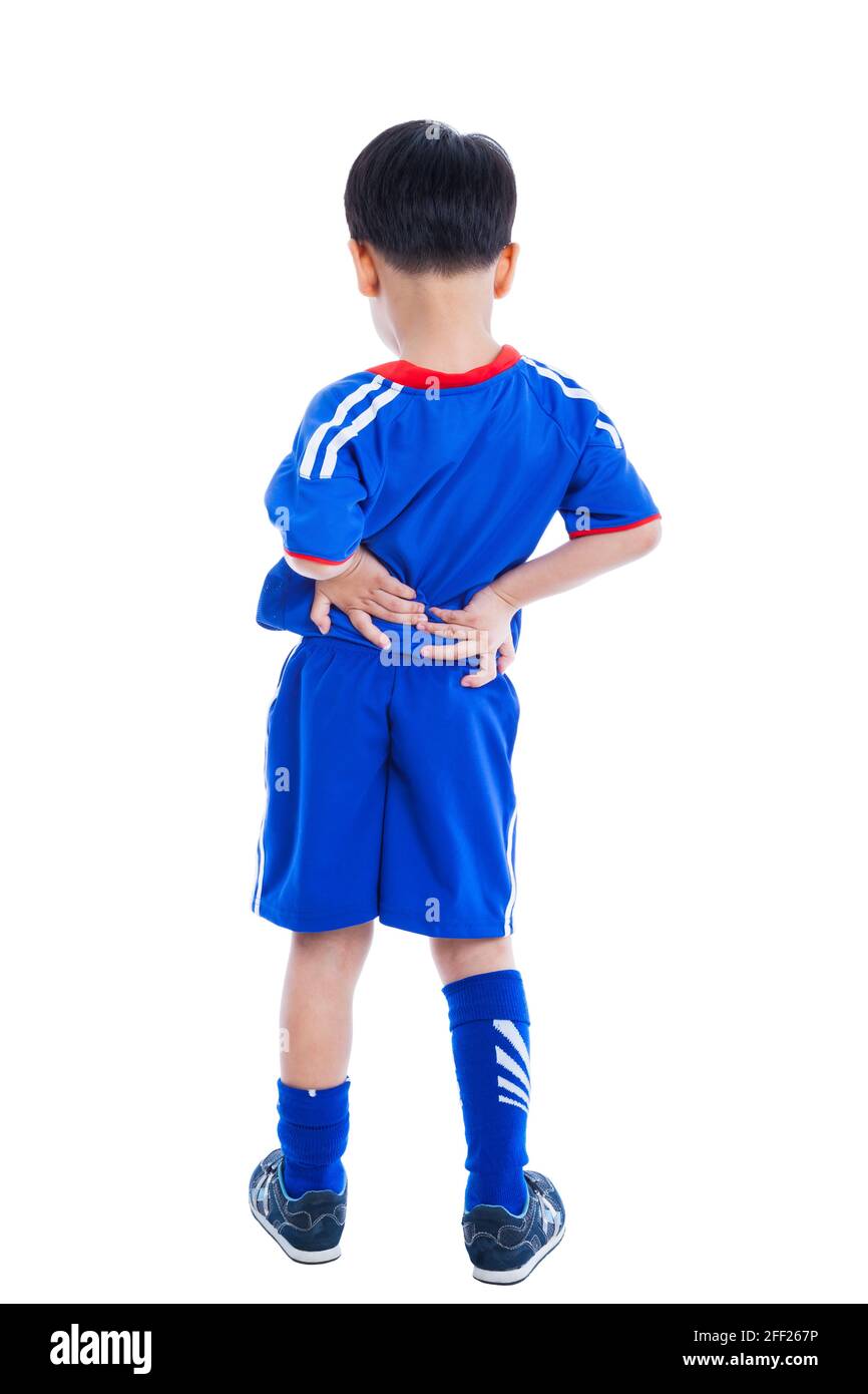 Rückenschmerzen. Athlet kleiner asiatischer (thailändischer) Junge in blauer Sportkleidung, der auf weißem Hintergrund isoliert auf den Muskeln seines unteren Rückens steht und sich reibt. Studio Stockfoto