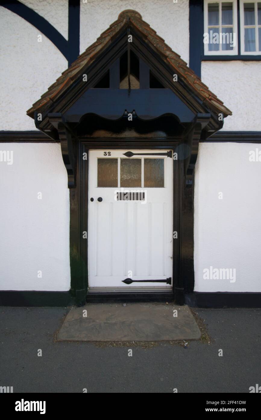 Alte englische weiße Eingangstür in einem denkmalgeschützten Gebäude im Tudor-Stil Stockfoto