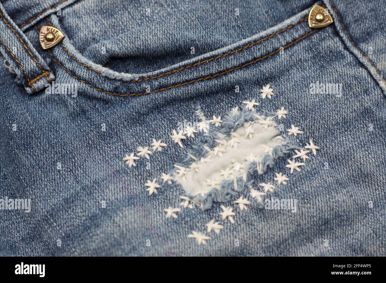 Jeans mit einem Loch, das schlampig mit gestickten Sternen geflickt wurde  Stockfotografie - Alamy