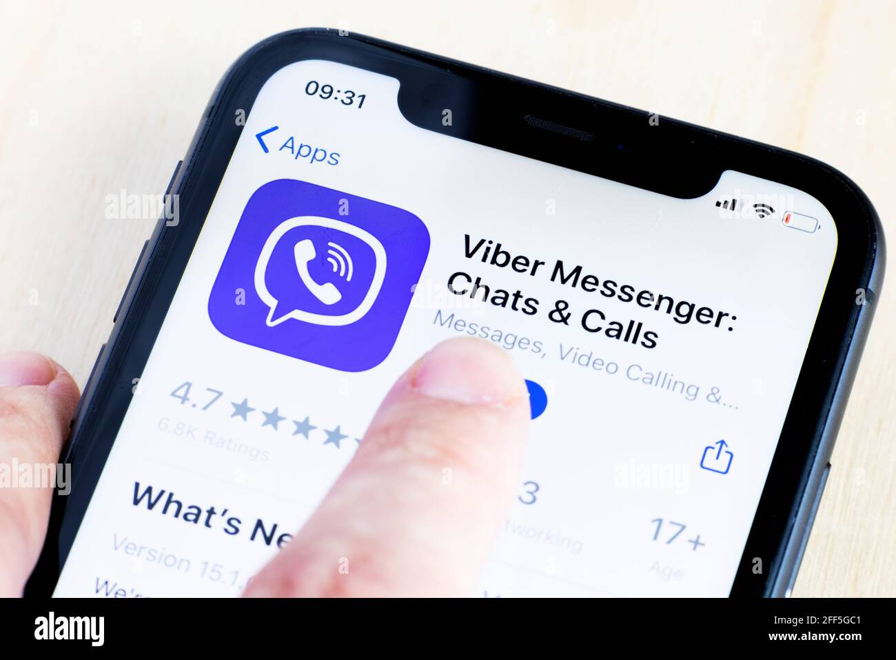 Junge Frau hält ein Smartphone mit Viber Messenger App auf dem Bildschirm. IPhone 11 mit einem Logo der Social Media-App für Chats und Anrufe. Stockfoto