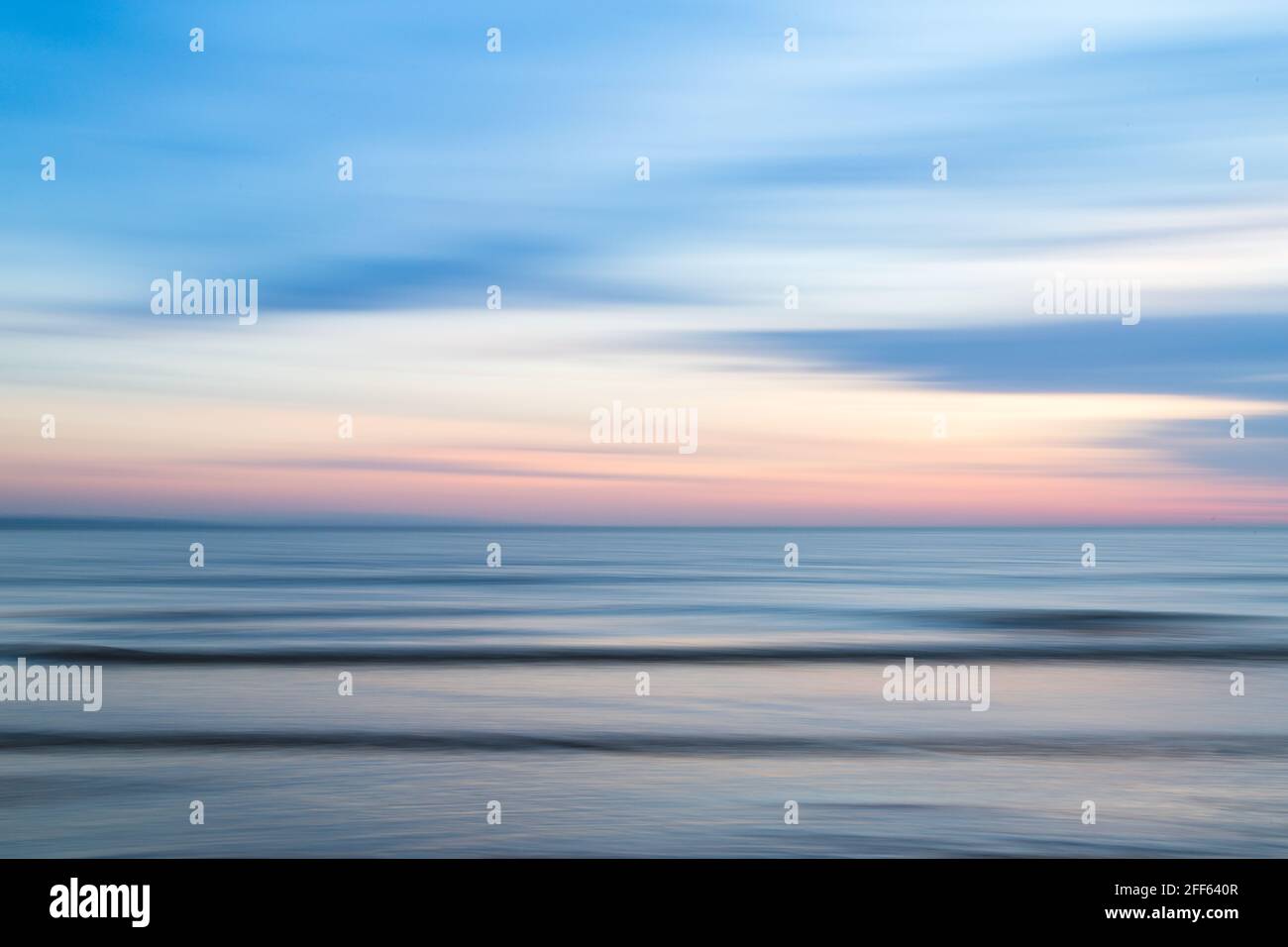 Ein absichtlich unscharfes Bild, das durch Schwenken der Kamera während einer langen Belichtung am Strand von Crosby in der Nähe von Liverpool in der Abenddämmerung entsteht. Stockfoto