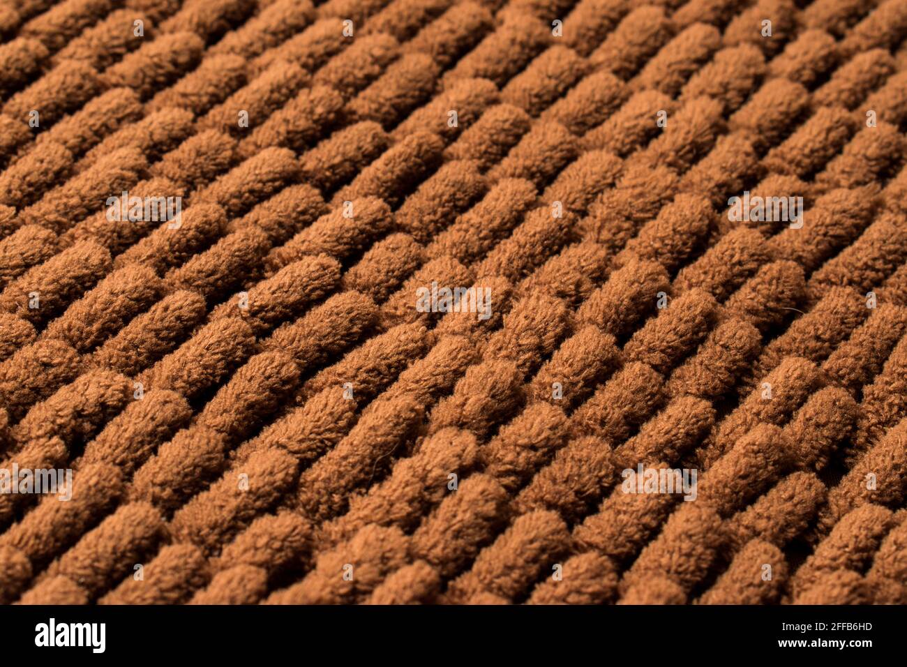 Nahaufnahme der braunen und weichen Teppichstruktur mit Linie Muster Stockfoto