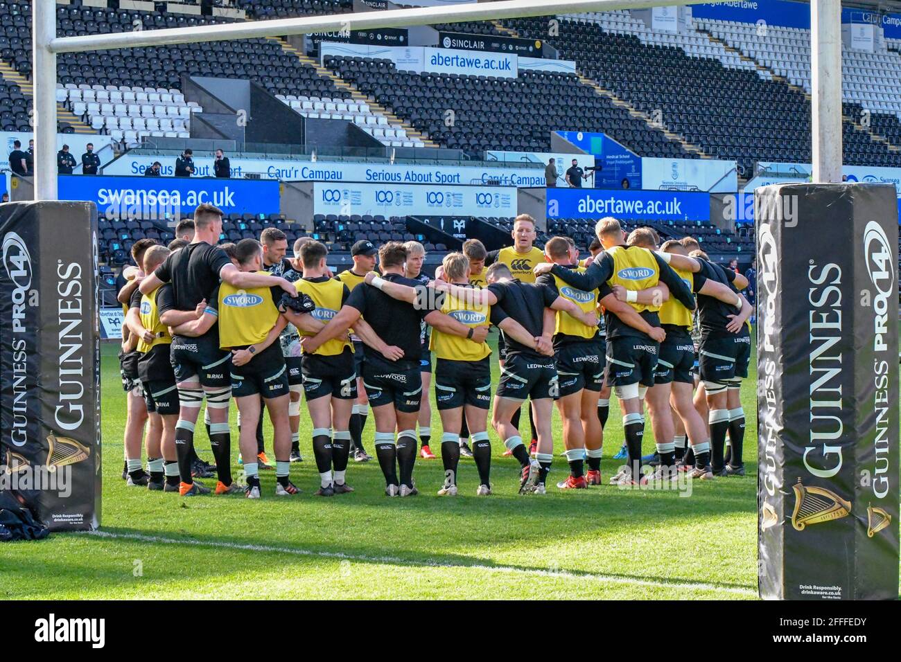 Swansea, Großbritannien. April 2021. Die Ospreys-Mannschaft huddle beim Aufwärmen vor dem Guinness PRO14 Rainbow Cup-Spiel zwischen Ospreys und Cardiff Blues am 24. April 2021 im Liberty Stadium in Swansea, Wales, Großbritannien. Sportstadien in ganz Großbritannien unterliegen aufgrund der Coronavirus-Pandemie weiterhin strengen Beschränkungen, da staatliche Gesetze zur sozialen Distanzierung Fans innerhalb von Veranstaltungsorten verbieten, was dazu führt, dass Spiele hinter verschlossenen Türen gespielt werden. Quelle: Duncan Thomas/Majestic Media/Alamy Live News. Stockfoto