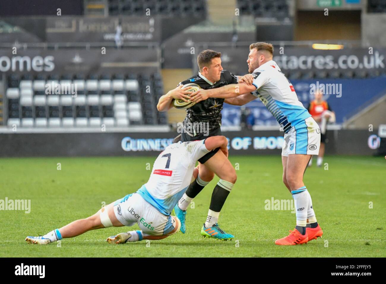 Swansea, Großbritannien. April 2021. Owen Watkin von Ospreys wird am 24. April 2021 im Liberty Stadium in Swansea, Wales, Großbritannien, von Gwilym Bradley von Cardiff Blues und Owen Lane von Cardiff Blues im Guinness PRO14 Rainbow Cup ausgetragen. Sportstadien in ganz Großbritannien unterliegen aufgrund der Coronavirus-Pandemie weiterhin strengen Beschränkungen, da staatliche Gesetze zur sozialen Distanzierung Fans innerhalb von Veranstaltungsorten verbieten, was dazu führt, dass Spiele hinter verschlossenen Türen gespielt werden. Quelle: Duncan Thomas/Majestic Media/Alamy Live News. Stockfoto