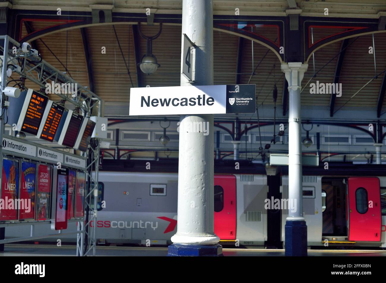 Newcastle, England, Vereinigtes Königreich. Ein sonnenbeleuchtetes Bahnhofschild und ein Teil des Zugsschuppens in Newcastle, einem Hauptterminal in Nordengland. Stockfoto