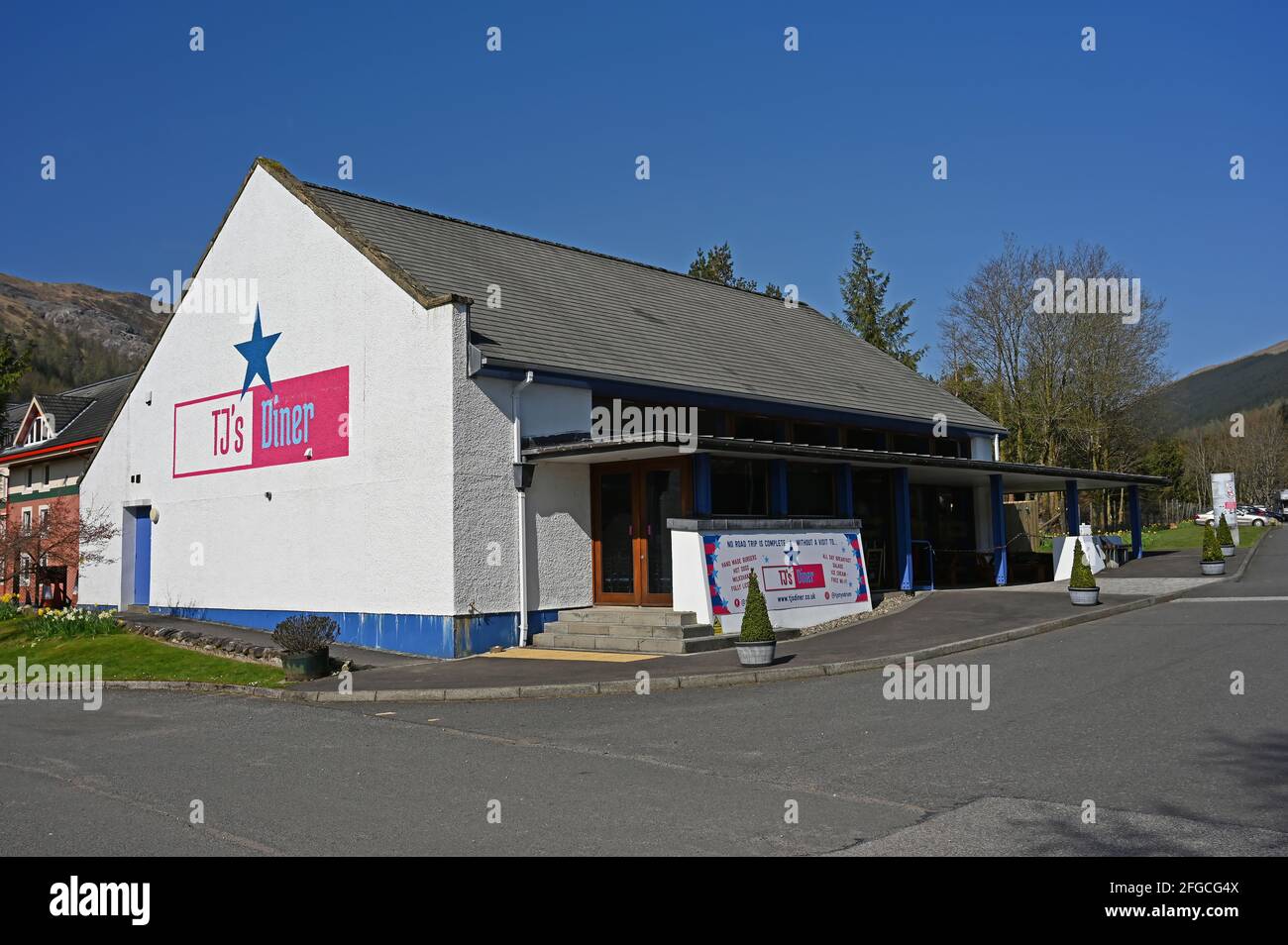 Außenansicht des TJS Diner in Tyndrum, Schottische Highlands. Sonniger Tag mit blauem wolkenlosem Himmel. Keine Personen. Stockfoto