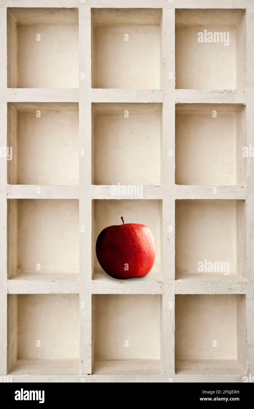 Zusammensetzung aus einem roten Apfel in einer weißen Schachtel Stockfoto
