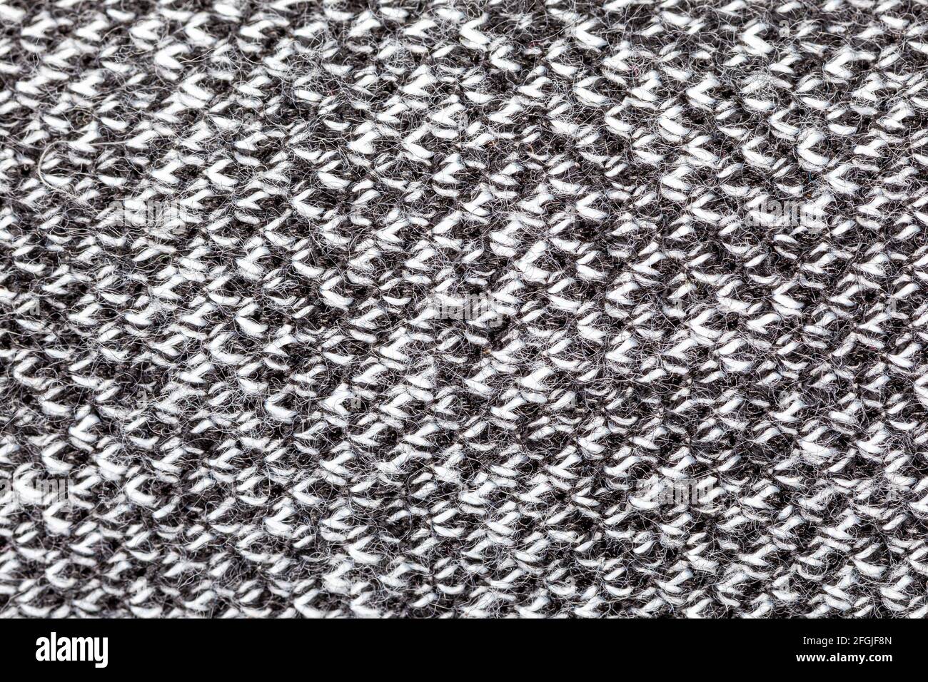 Schwarz-weiß gewebtes synthetisches Material raue Struktur Makro, extreme Nahaufnahme, abstrakte graue Textiloberfläche, Draufsicht, einfacher Hintergrund te Stockfoto