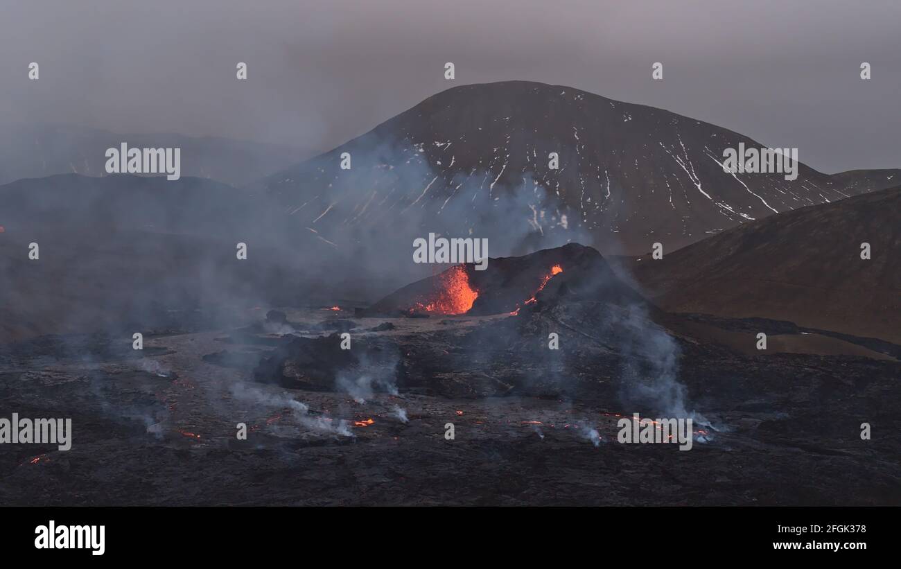 Atemberaubende Aussicht auf den Vulkanausbruch im Geldingadalir-Tal in der Nähe des Fagradalsfjall, Grindavík, Halbinsel Reykjanes, Südwesten Islands mit Rauch. Stockfoto