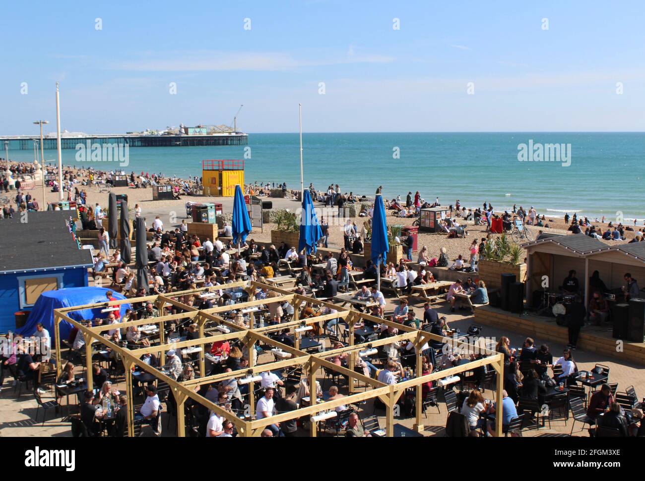 Nach der Lockerung der Sperrungsbeschränkungen kehren die Massen in die Strandkneipen von Brighton zurück. Speisen unter freiem Himmel, bei denen sich die Gäste amüsieren. Schöner Frühlingstag. Stockfoto