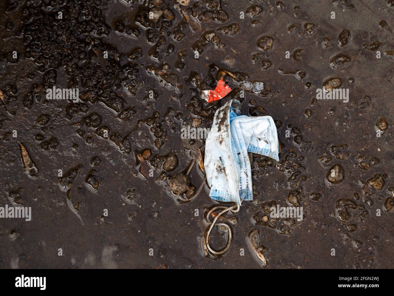 Bild einer gebrauchten medizinischen Maske im Schmutz Stockfoto