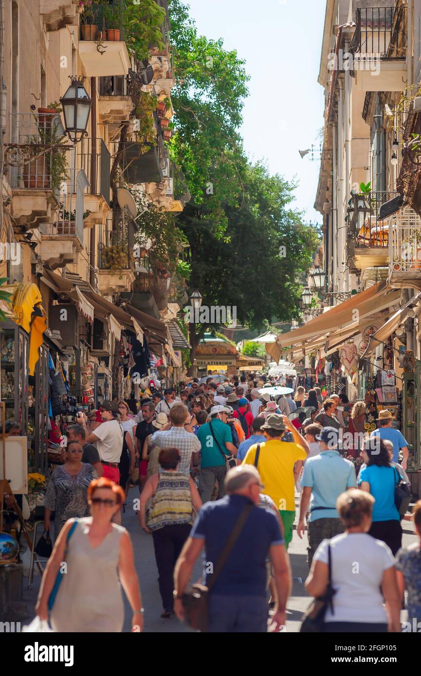 Italien Straße, Blick im Sommer von Touristen in einer belebten Durchgangsstraße in der Altstadt von Taormina, Sizilien, Italien, Europa. Stockfoto