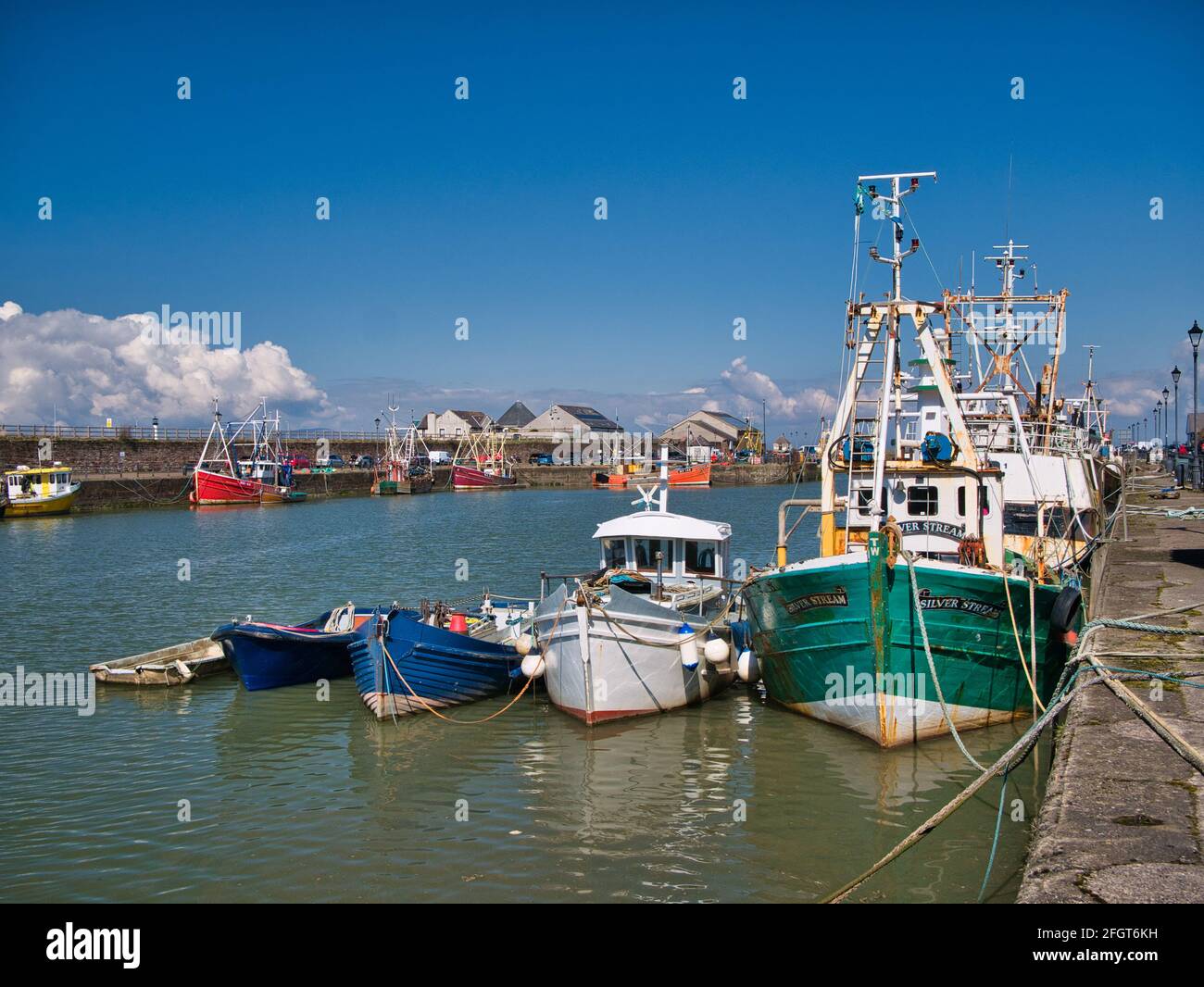 Fünf Boote in abnehmender Größe liegen in Maryport an der Solway Coast in Cumbria, Großbritannien. Aufgenommen an einem sonnigen Tag im Frühling. Stockfoto