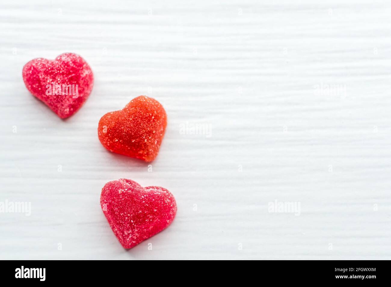 Drei kleine rote Herzen auf weißem Hintergrund. Grußkarte. Stockfoto