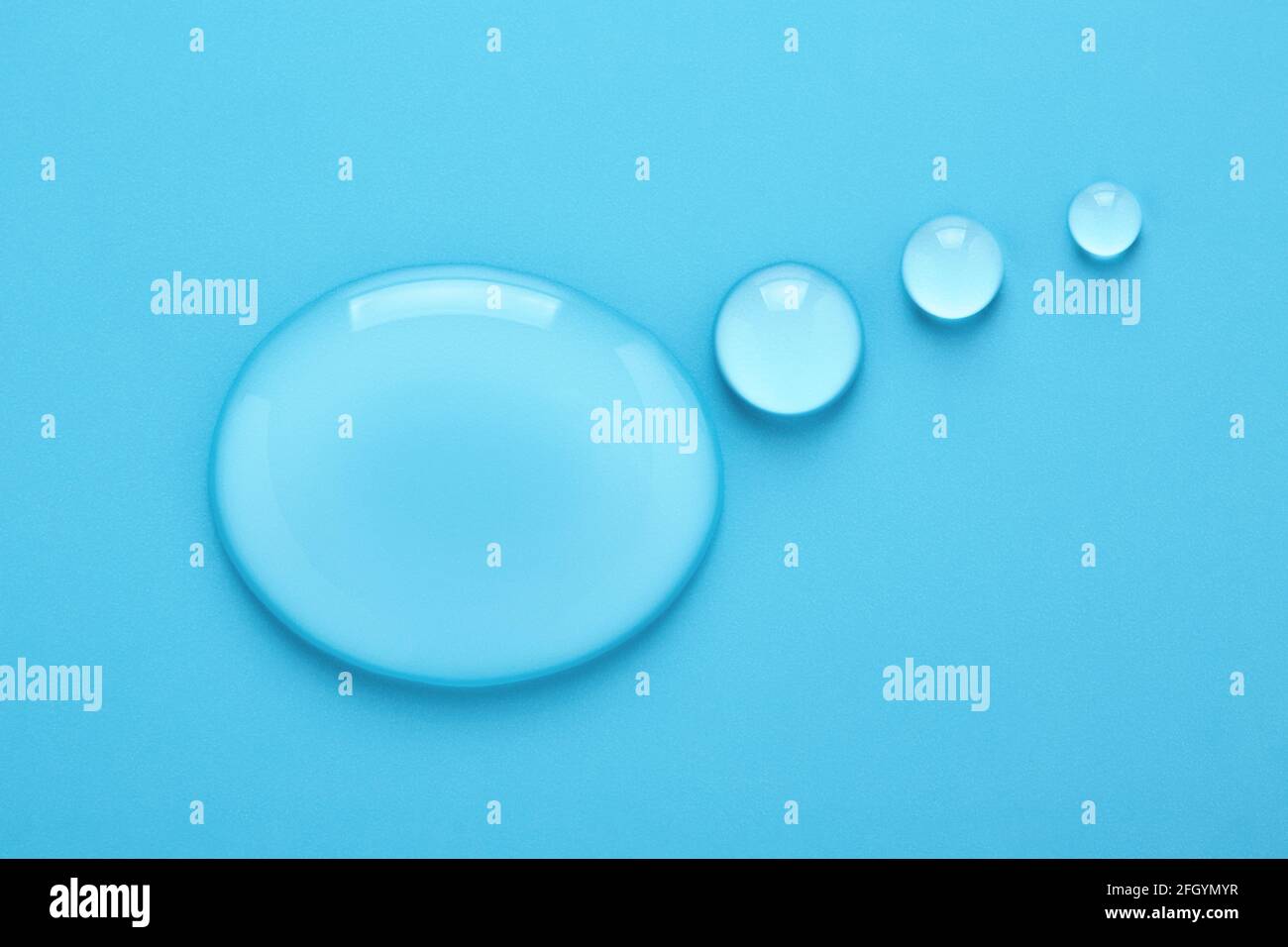 Wasser tropft in Form einer Gedankenblase auf blauem Hintergrund. Stockfoto
