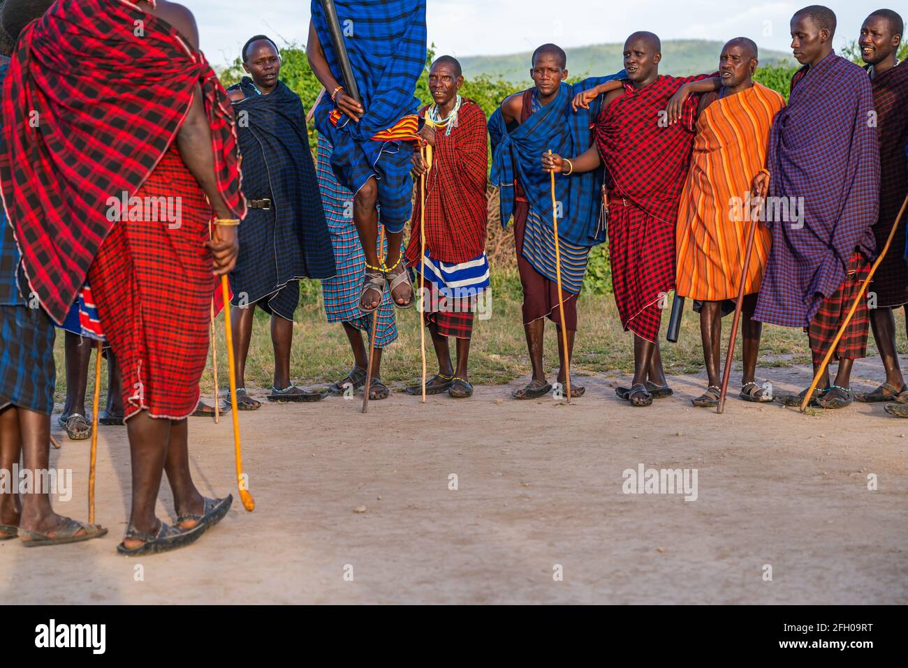 NGORONGORO, TANSANIA - 15. Februar 2020: Gruppe von massai-Kriegern, die an einem traditionellen Tanz teilnehmen, Füße von einem Mann springen hoch, ausgewählter Fokus Stockfoto