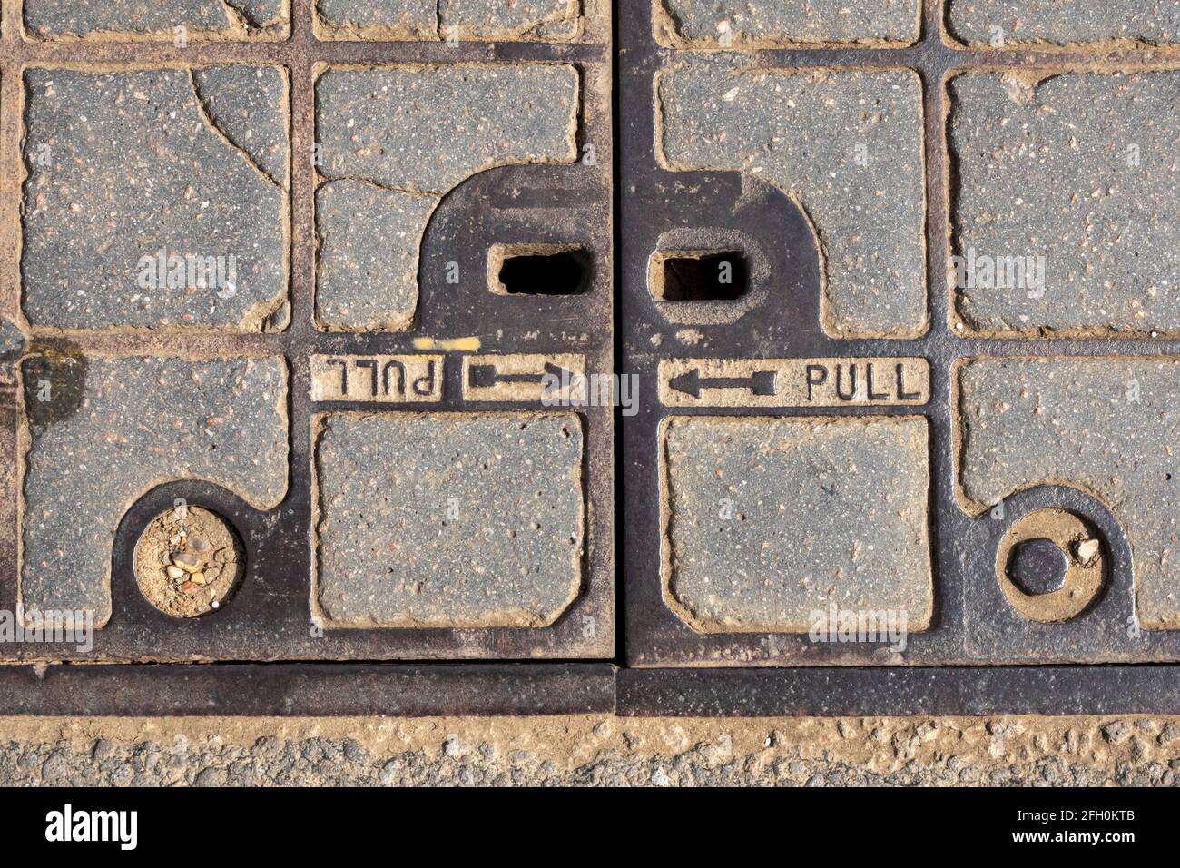 Posttelefone Inspektionsabdeckung aus Gusseisen und Beton Auf der Fahrbahn montiert Stockfoto