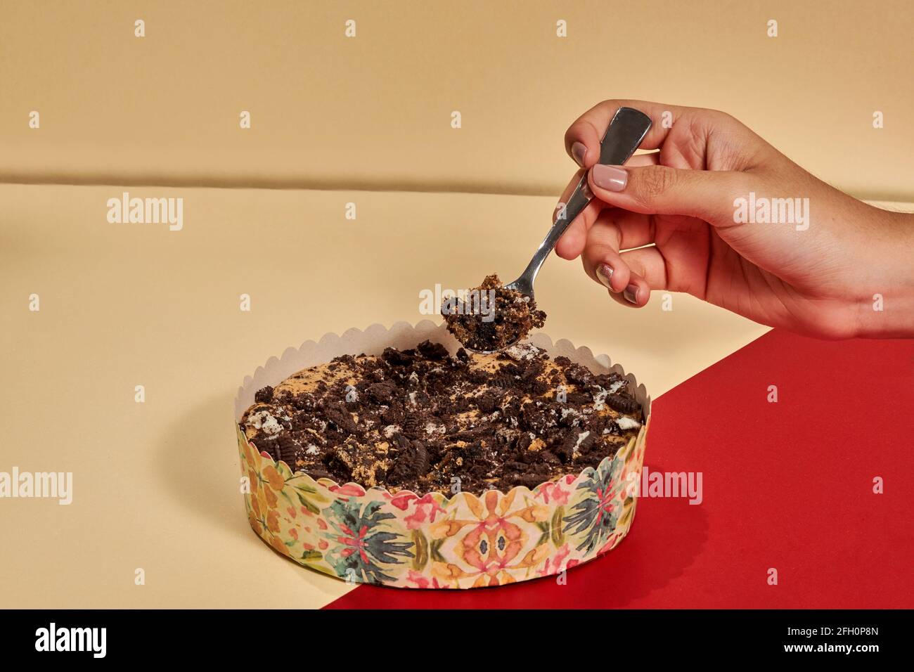 Hand nehmen einen Löffel Kuchen aus dem Behälter auf den Tisch Stockfoto