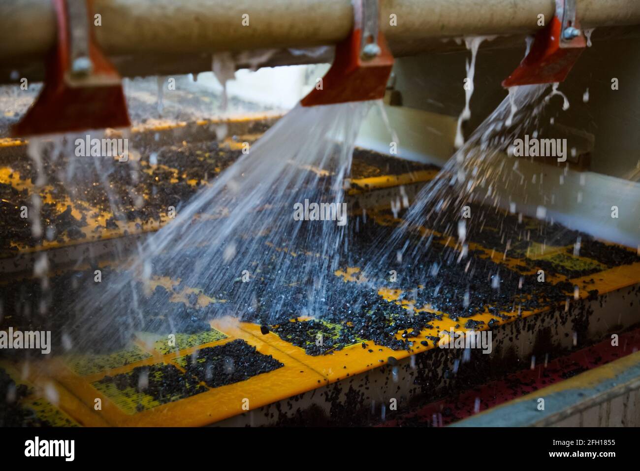 Golderz-Steine waschen und konzentrieren sich mit Wasser und vibrierendem Bildschirm. Goldbergbau- und Verarbeitungsanlage, Akbakay, Kasachstan. Stockfoto