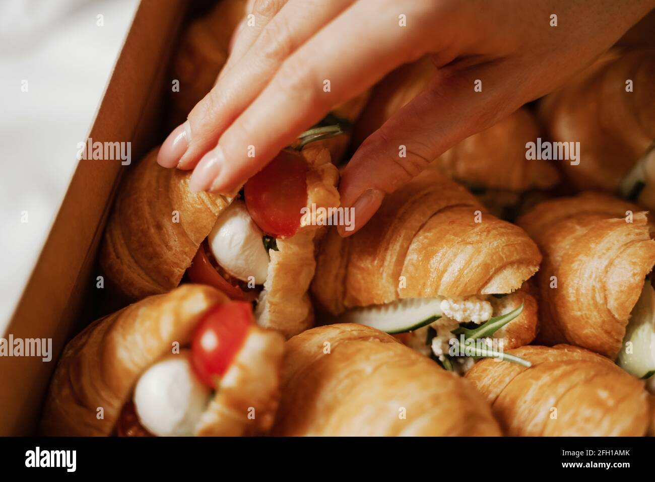 Nahaufnahme der Lebensmittelbox, frisches Croissant, Hand Stockfoto
