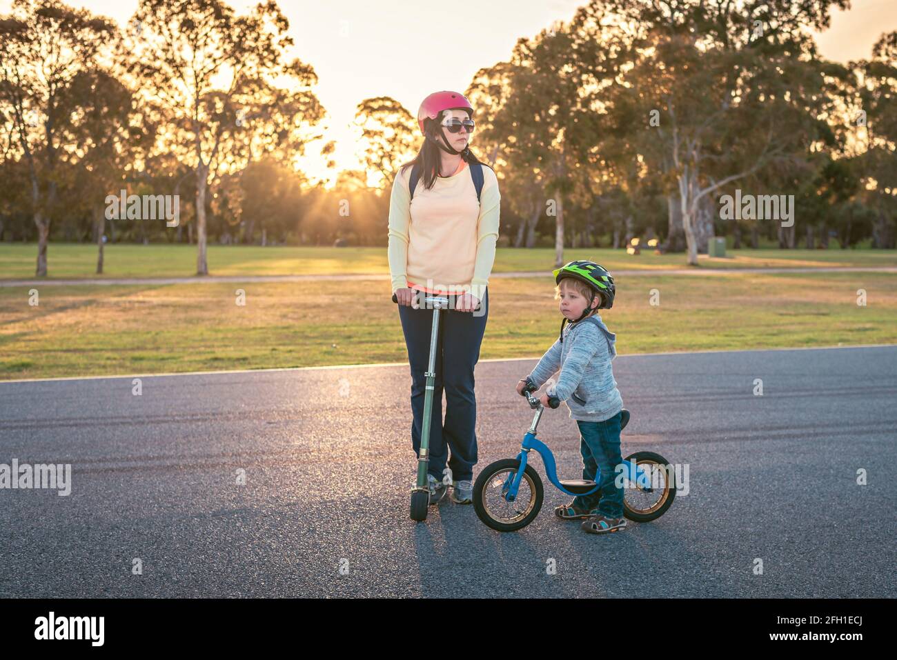 Mutter mit ihrem Sohn, der im Adelaide Adelaide Park Scooter reitet Land Stockfoto