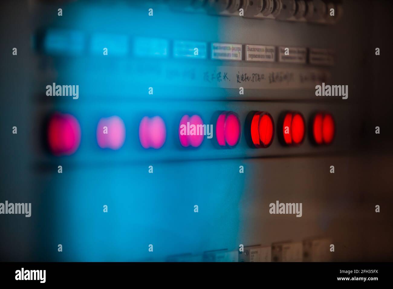 Wasserkraftwerk Moinak. Blaues Bedienfeld. Rote Anzeigelampen. Geringe Schärfentiefe, teilweise unscharf. Stockfoto