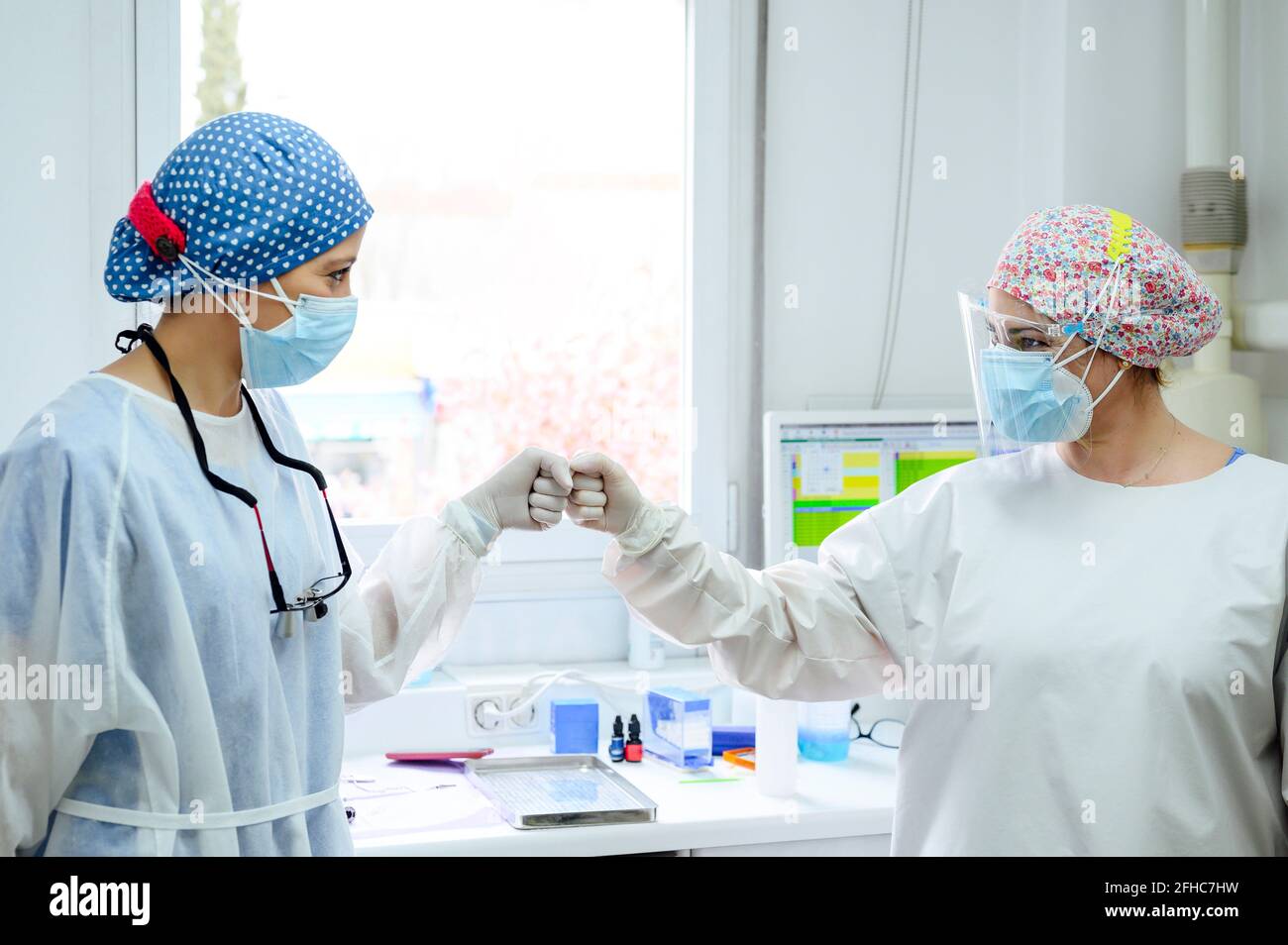 Ärzte in Uniformen begrüßen sich gegenseitig mit hohen fünf an Arbeiten im Krankenhaus Stockfoto