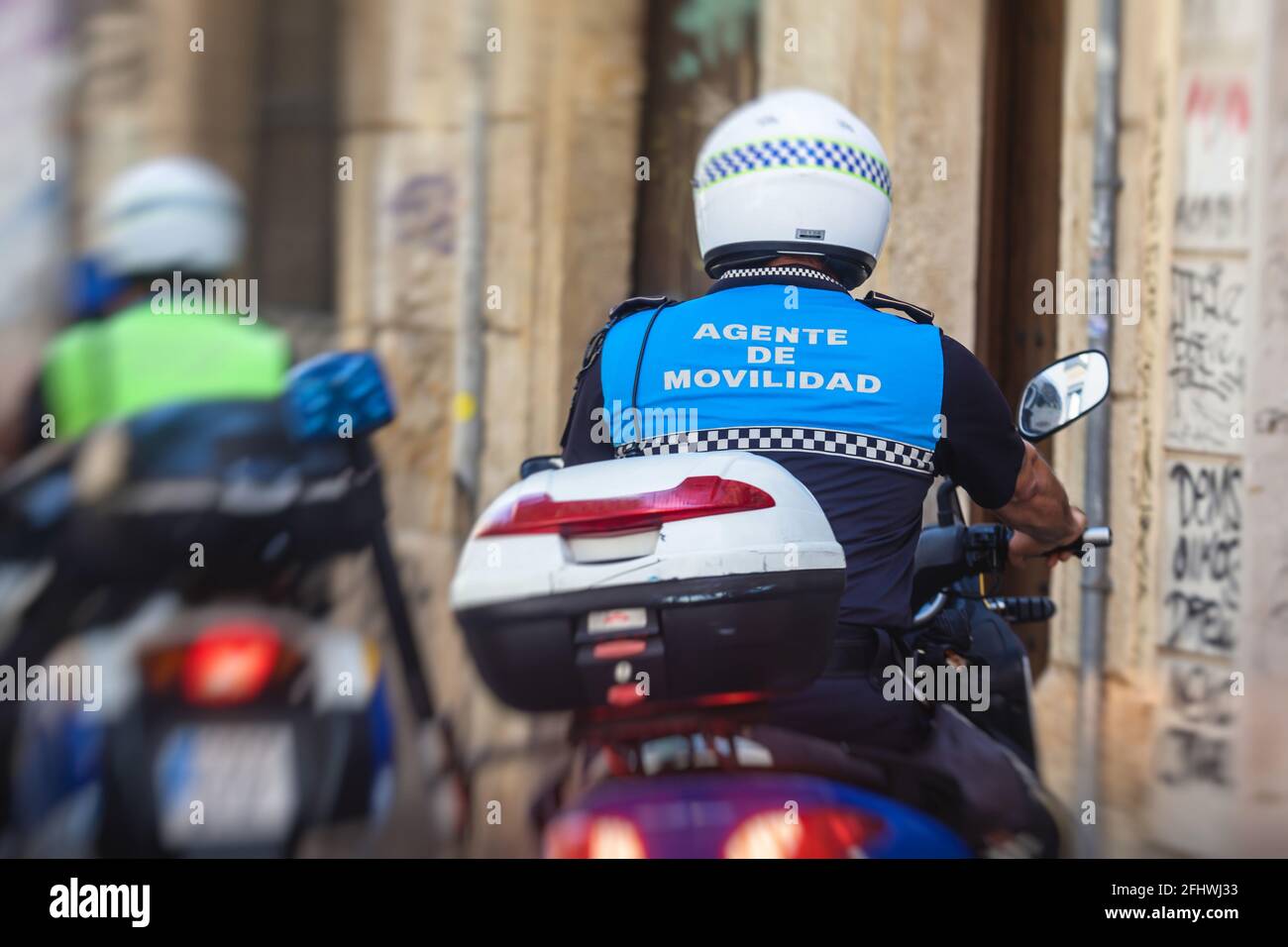 Spanische Polizeigruppe Formation auf Fahrrad und Motorrad Rückansicht Mit dem Logo „Local Police“ auf Uniform, um die öffentliche Ordnung zu erhalten In den Straßen von Ali Stockfoto