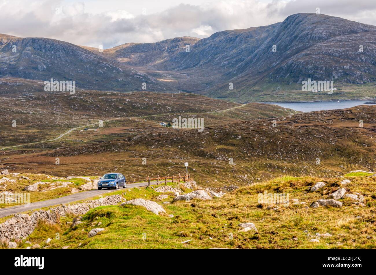 Die eingleisige B887 Huisinish Road entlang der nördlichen Küste von West Loch Tarbert mit den Bergen von North Harris im Hintergrund. Stockfoto