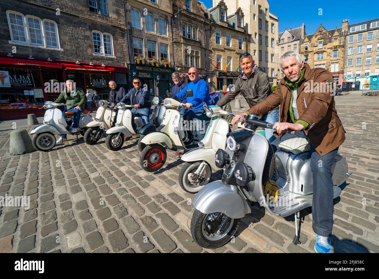 Edinburgh, Schottland, Großbritannien. 25. April 2021. Szenen aus den Straßen des Stadtzentrums von Edinburgh am Sonntagnachmittag am Tag, bevor nicht unbedingt erforderliche Geschäfte und Unternehmen in Schottland unter entspannten Covid-19-Sperrregeln wieder eröffnet werden können. Abb. Mitglieder des Edinburgh Central Scooter Club ruhen sich während einer Fahrt am Sonntagnachmittag in Grassmarket aus. Iain Masterton/Alamy Live News Stockfoto