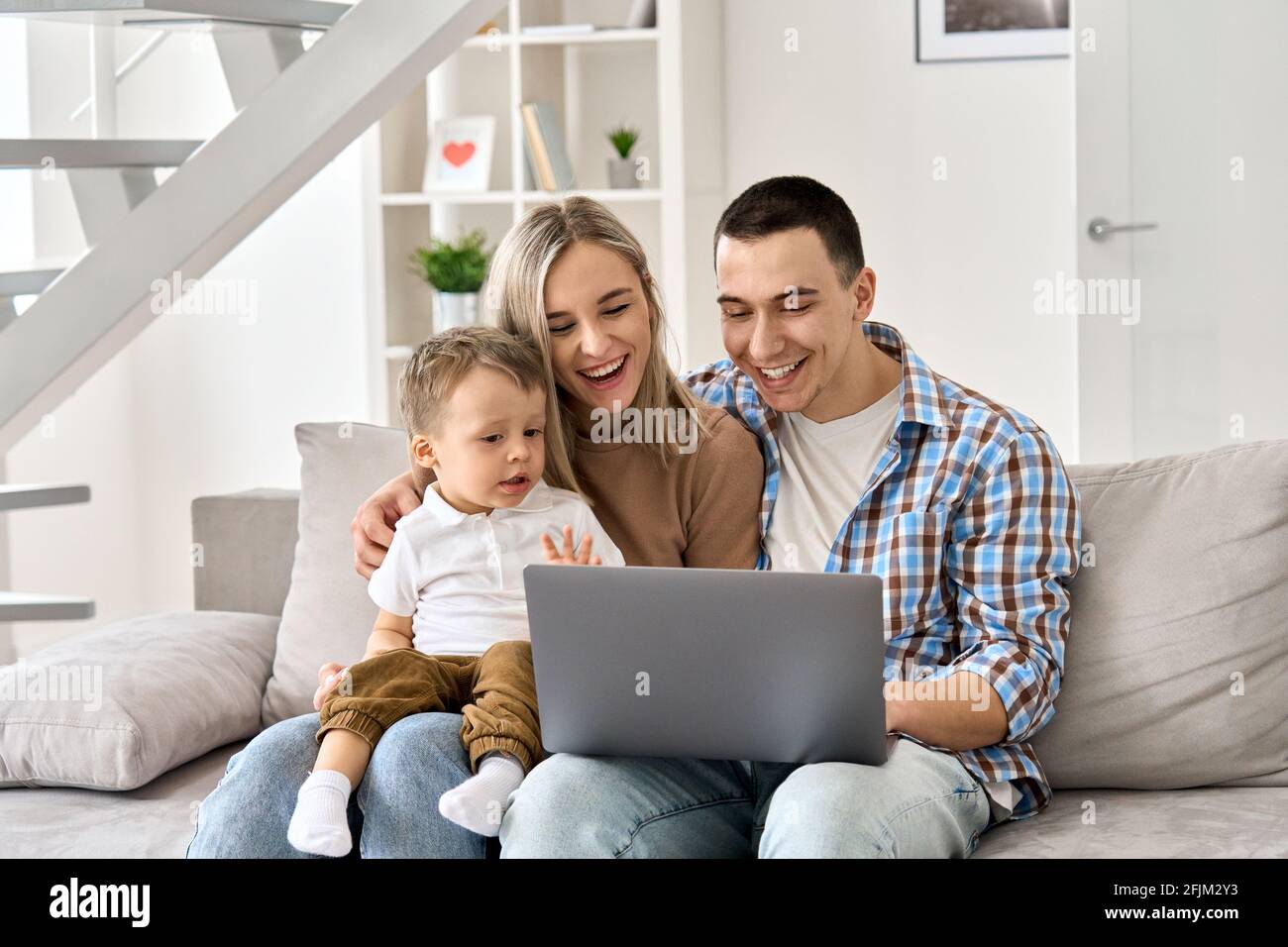 Glückliche Eltern und Kind Sohn winken mit virtuellen Treffen mit Laptop zu Hause. Stockfoto