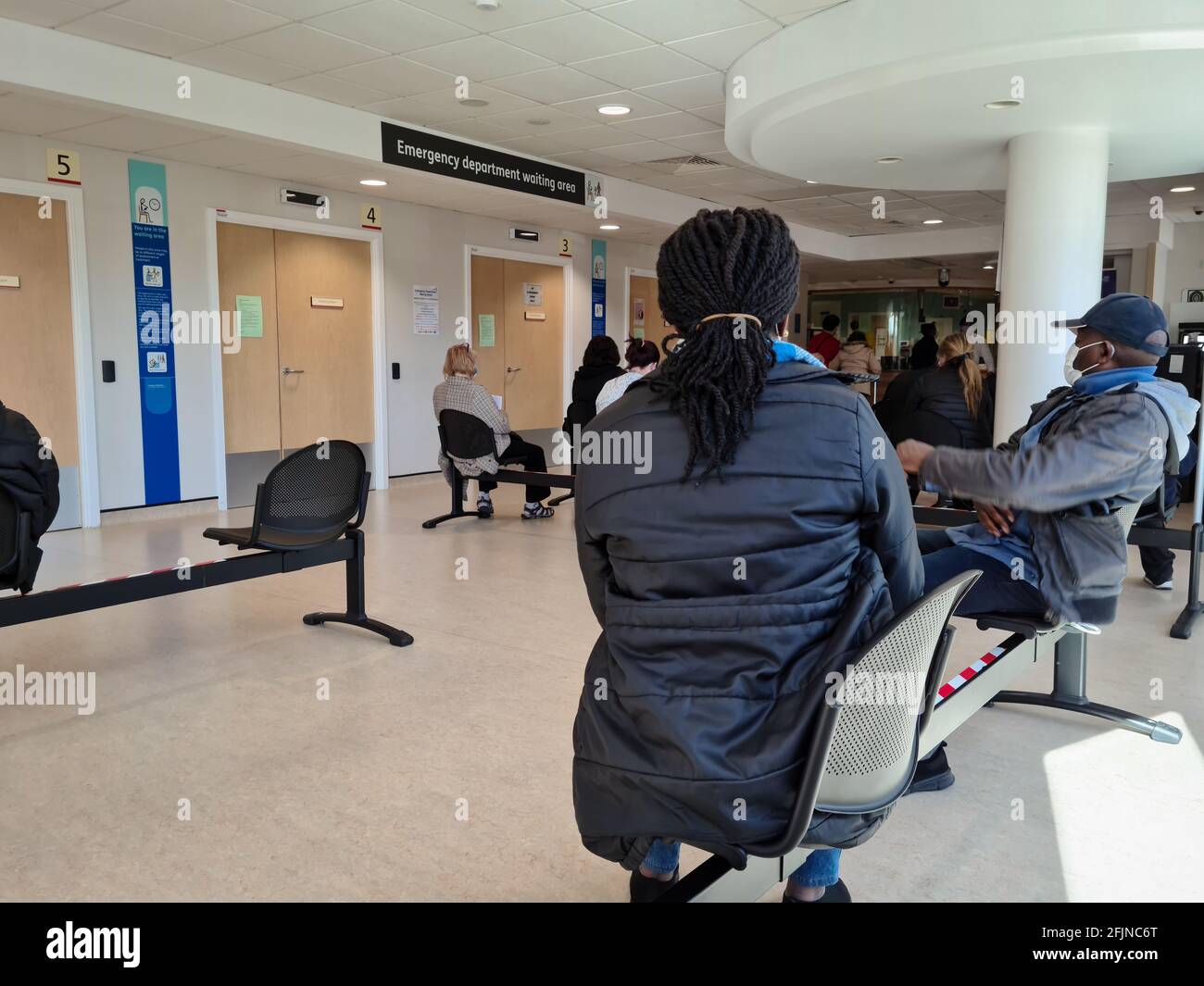 Personen im Wartezimmer eines NHS-Allgemeinkrankenhauses Unfall- und Notaufnahme warten auf medizinische Behandlung. Stockfoto