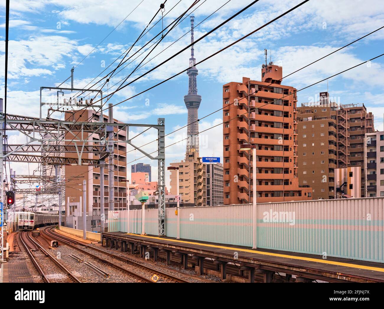 tokio, japan - 25 2021. april: Tobu Isesaki Line-Zug, der die Eisenbahn des Kanegafuchi-Bahnhofs mit dem höchsten Turm Tokyos, dem Skytree in BA, passiert Stockfoto