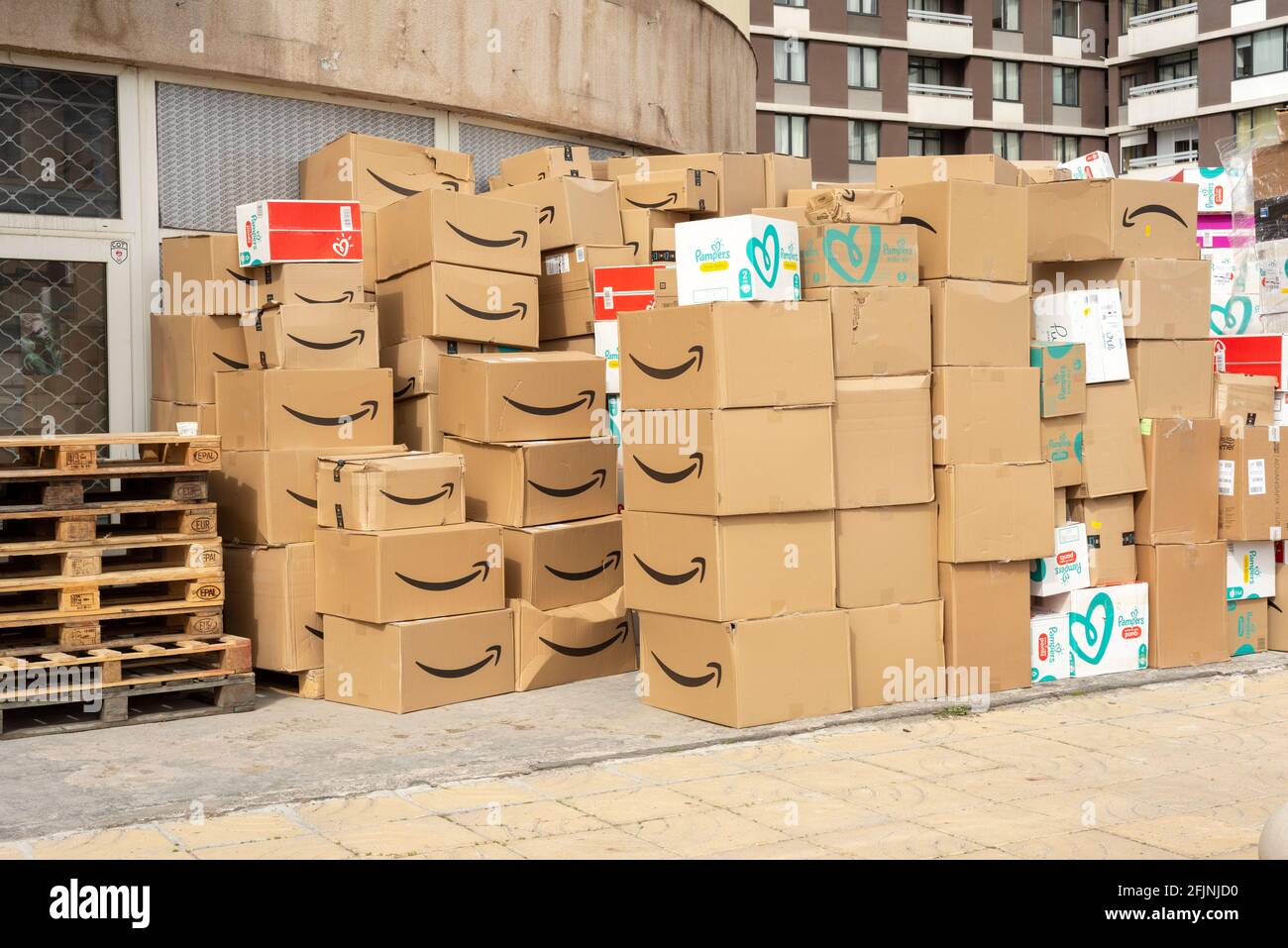 Stapel von Amazon-Versandkartons und -Paketen auf der Straße Außerhalb einer internationalen Anlieferungsstelle Stockfoto