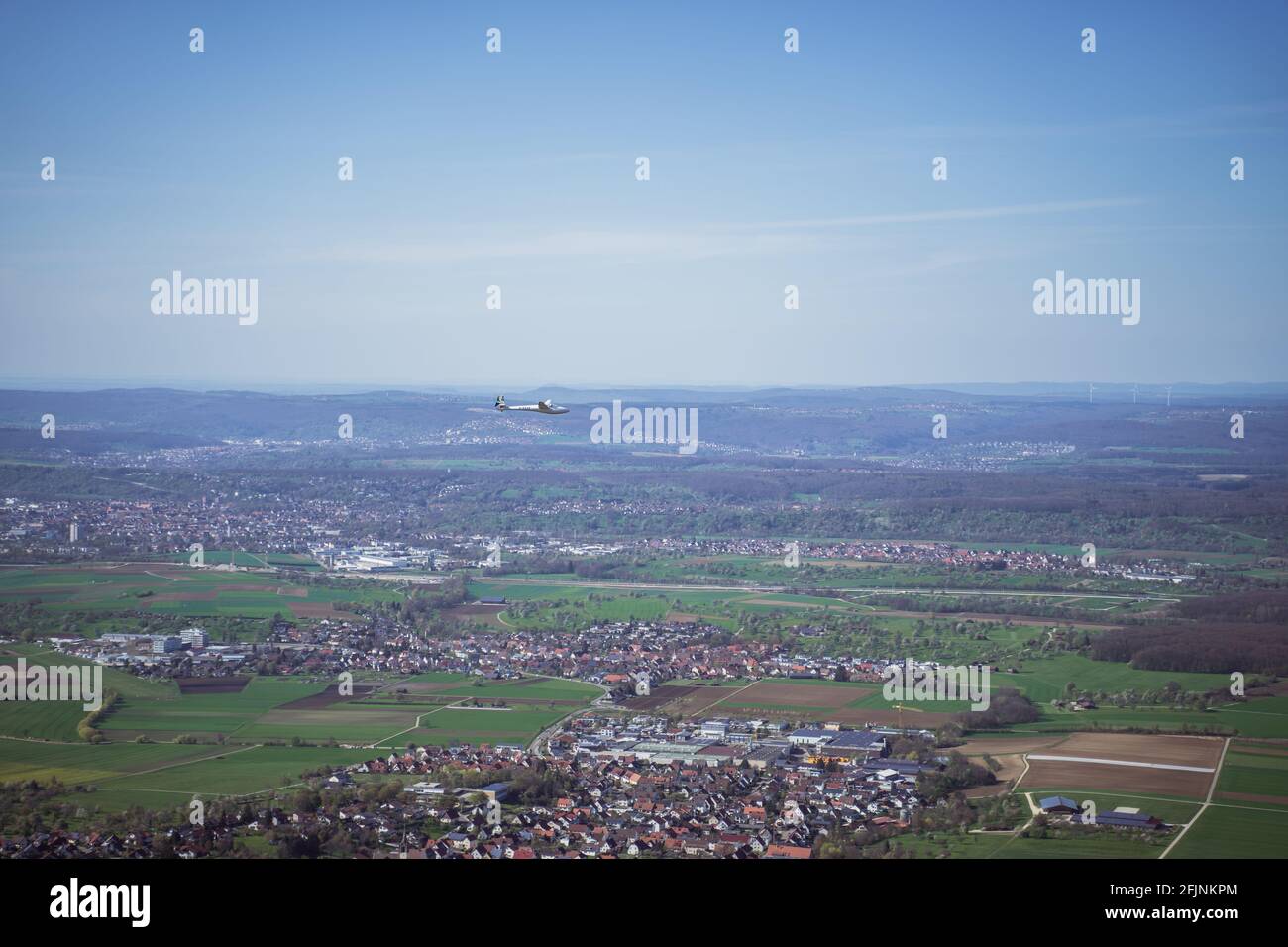 Der Segelflieger schwebt über ein Tal in Deutschland, in der Nähe von Stuttgart. Blick von einer Klippe zeigt die ländlichen Dörfer, viele Felder und Bäume in einem besiedelten Gebiet. Stockfoto