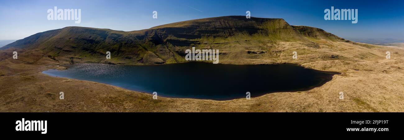 Panorama-Luftaufnahme eines wunderschönen gletscherförmigen Sees am Fuße eines Berges (Llan y Fan Fawr). Brecon Beacons, Wales Stockfoto