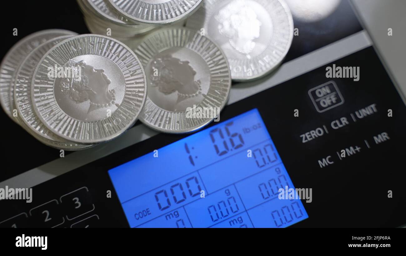 Silbermünzen auf präzisen Digitalwaagen. Geld, Investor und Finanz- und Wirtschaftskonzept. Stockfoto