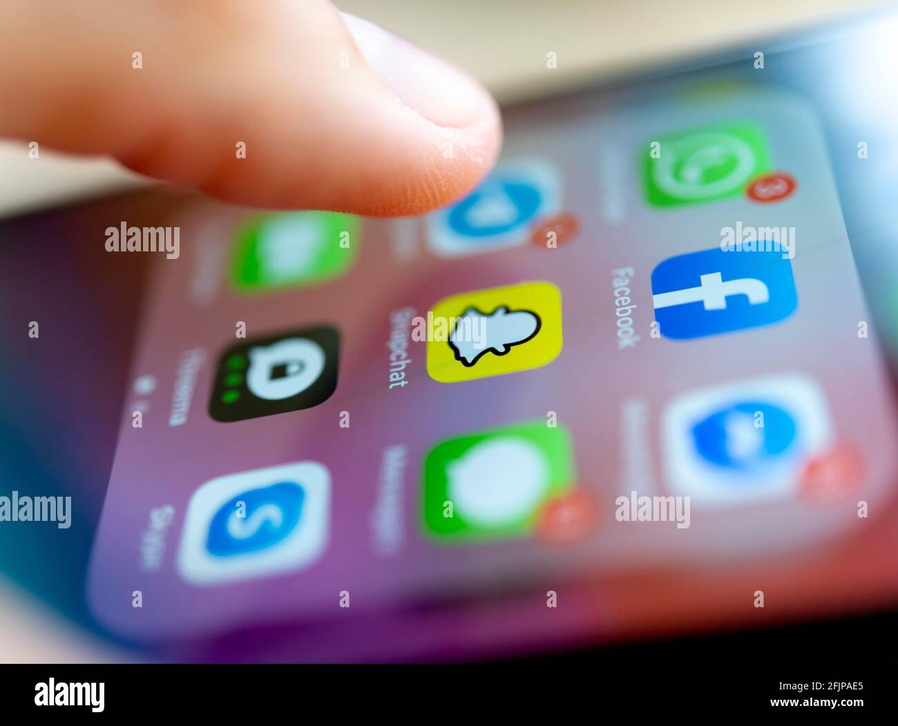 Fingertippen auf dem Bildschirm mit App-Symbolen von Messenger-Diensten und sozialen Netzwerken, WhatsApp, Facebook, Telegram, Snapchat, Threema, iPhone 11 Pro Stockfoto
