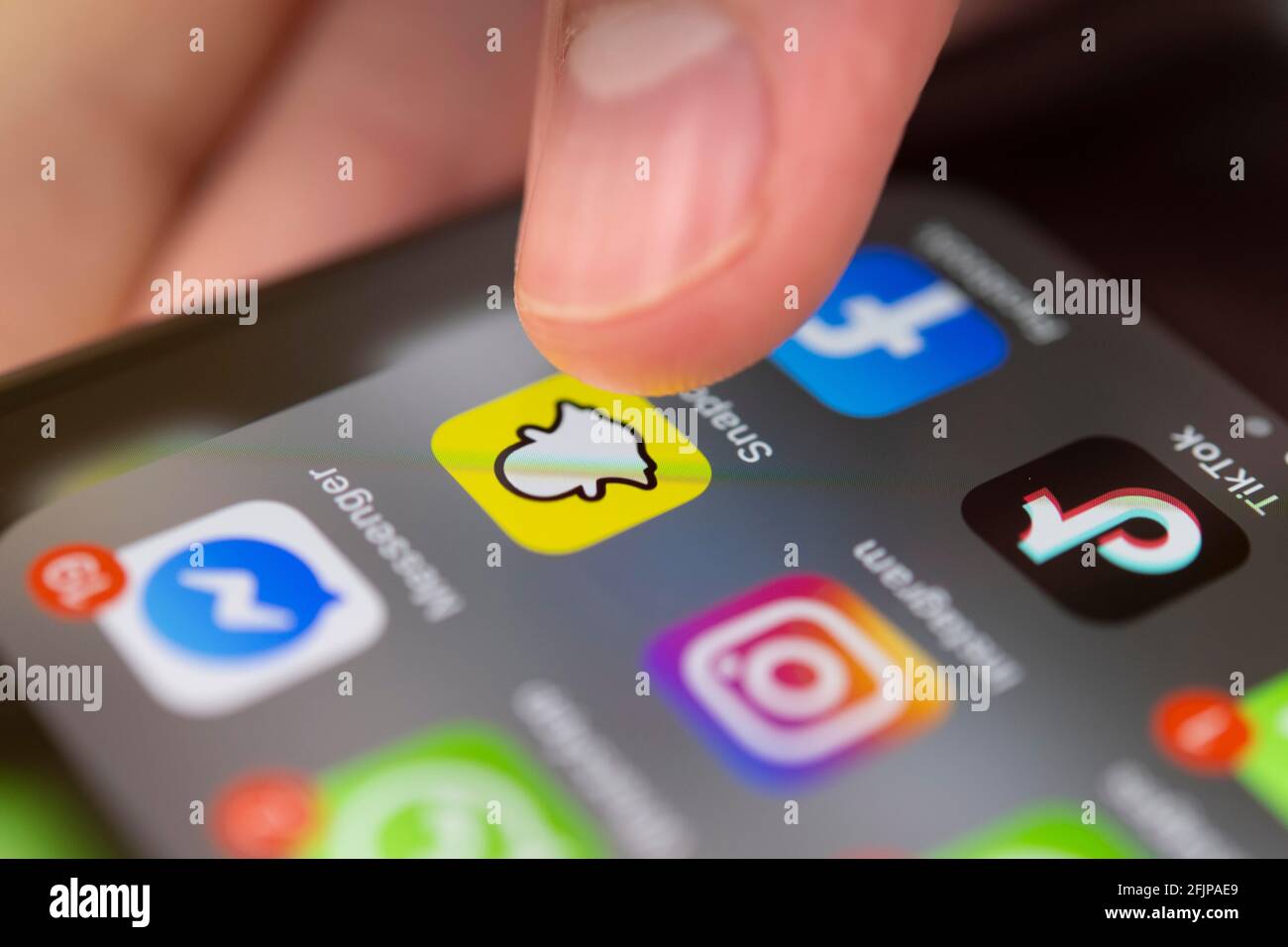 Fingertippen auf dem Bildschirm mit App-Symbolen von Messenger-Diensten und sozialen Netzwerken, WhatsApp, Facebook, Telegram, Snapchat, Threema, iPhone 11 Pro Stockfoto
