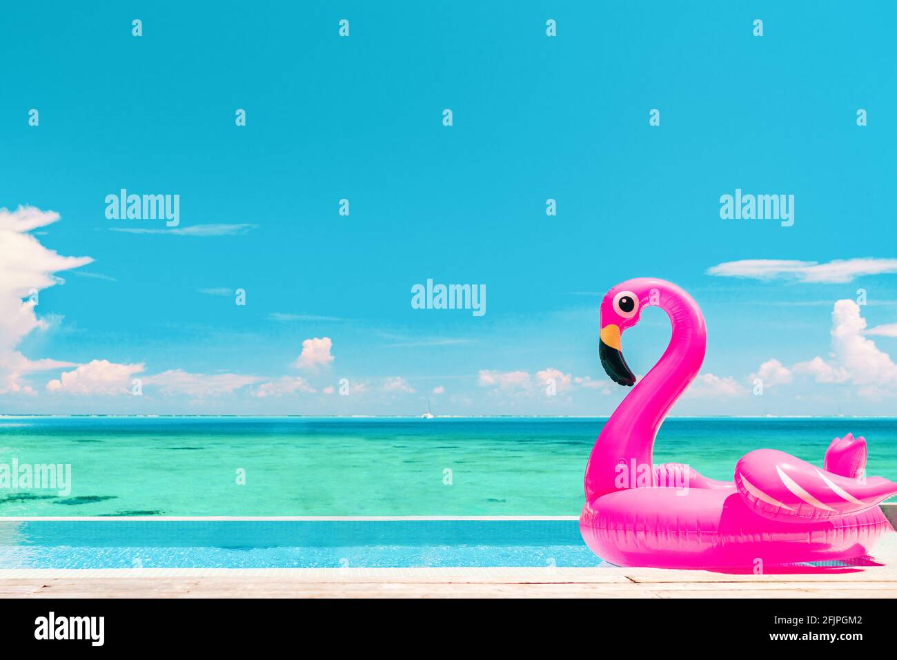 Reiseurlaubspool Strandreisekonzept mit aufblasbarer pinker Flamingo-Floatspielzeug-Matratze im luxuriösen Swimmingpool. Luxuriöser Lifestyle-Sommerurlaub Stockfoto