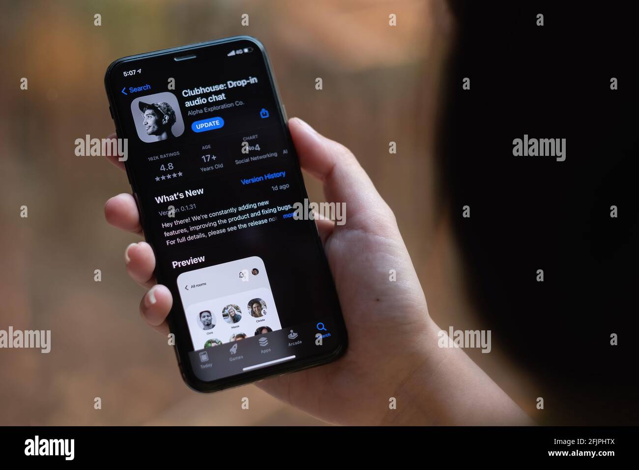 CHIANG MAI, THAILAND, 13 MAR 2021 : Frau in kabelgebundenen Kopfhörern hält Smartphone mit Clubhouse Drop in Audio-Chat-Anwendung auf dem Bildschirm. Neue soziale Netzwerke Stockfoto
