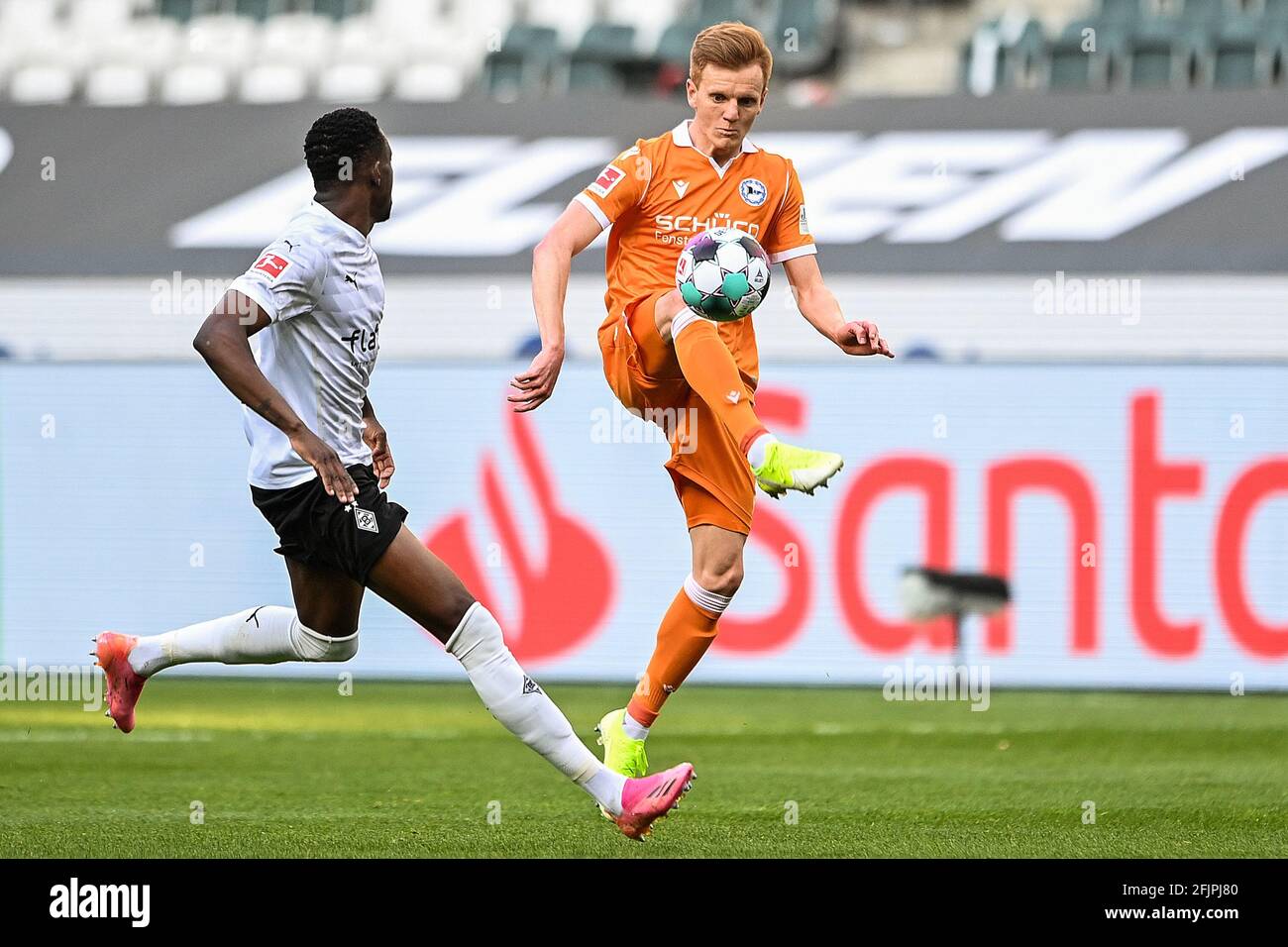 Mönchengladbach, Deutschland. April 2021. Christian Gebauer (R) aus Bielefeld kontrolliert den Ball unter der Abwehr von Denis Zakaria aus Mönchengladbach während eines Bundesliga-Spiels zwischen Borussia Mönchengladbach und Arminia Bielefeld am 25. April 2021 in Mönchengladbach. Quelle: Ulrich Hufnagel/Xinhua/Alamy Live News Stockfoto