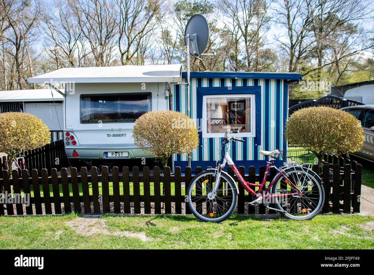 Friesoythe, Deutschland. April 2021. Auf dem Familiencampingplatz Wilken an  der Thülsfelder Talsperre steht vor einem Wohnwagen ein Fahrrad vor einem  Gartenzaun. Die Nachfrage nach Dauercampingplätzen in Niedersachsen ist  größer als das Angebot.