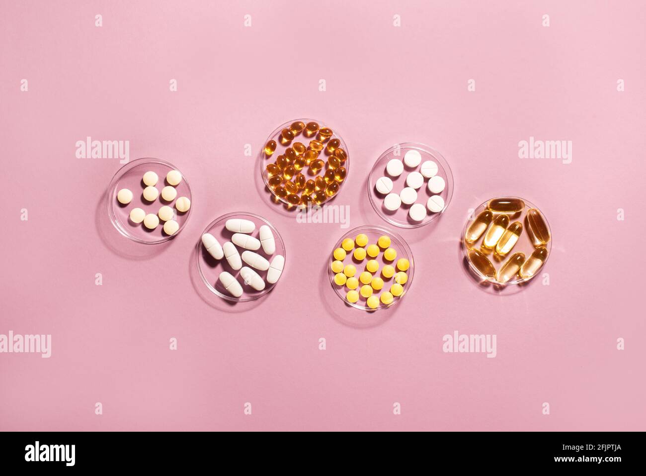 Vitamine Kapseln und Pillen auf rosa Hintergrund, Draufsicht, Kopierraum. Nahrungsergänzungsmittel: Fischöl, Omega 3, Omega 6, Omega 9, Vitamin A, D3, E, B, KAL Stockfoto