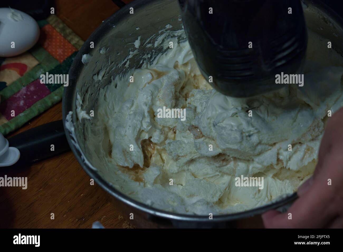 Ein elektrischer Mixer wirbelt eine Schüssel mit Ingeredance in ein Teig Stockfoto