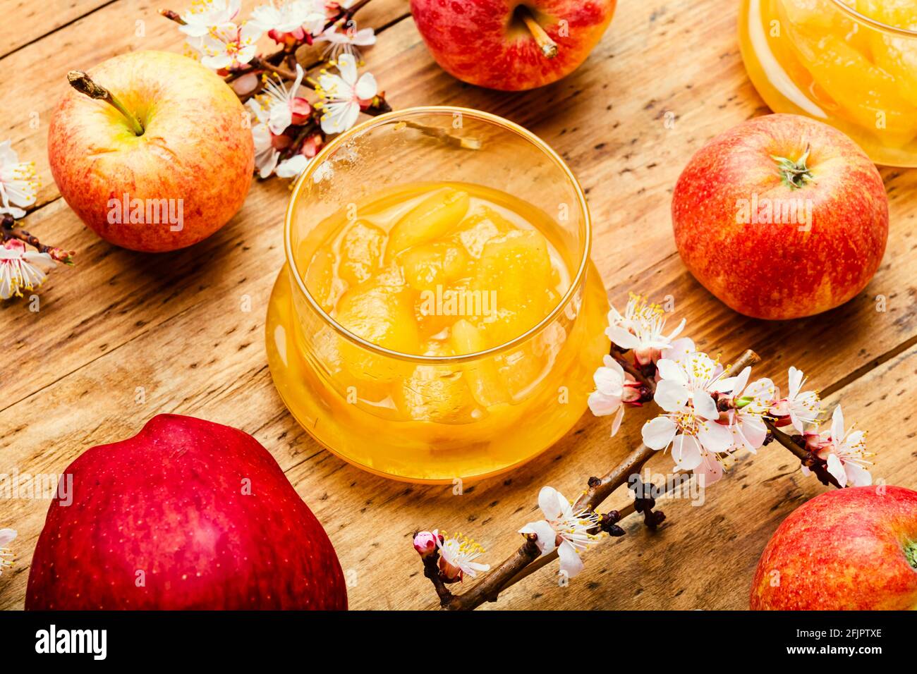 Apfelmarmelade im Glas und frische Äpfel auf rustikal Holzhintergrund Stockfoto